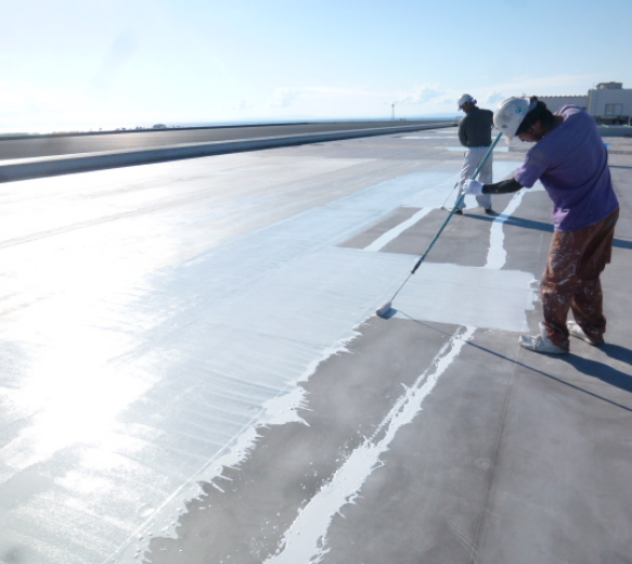 屋根で作業するスタッフ