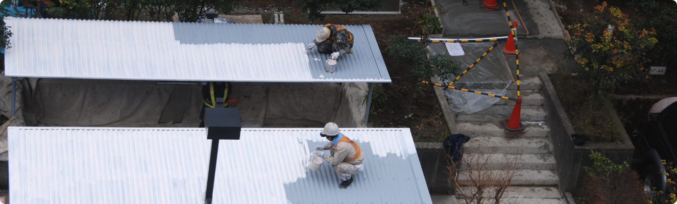屋根で作業するスタッフ